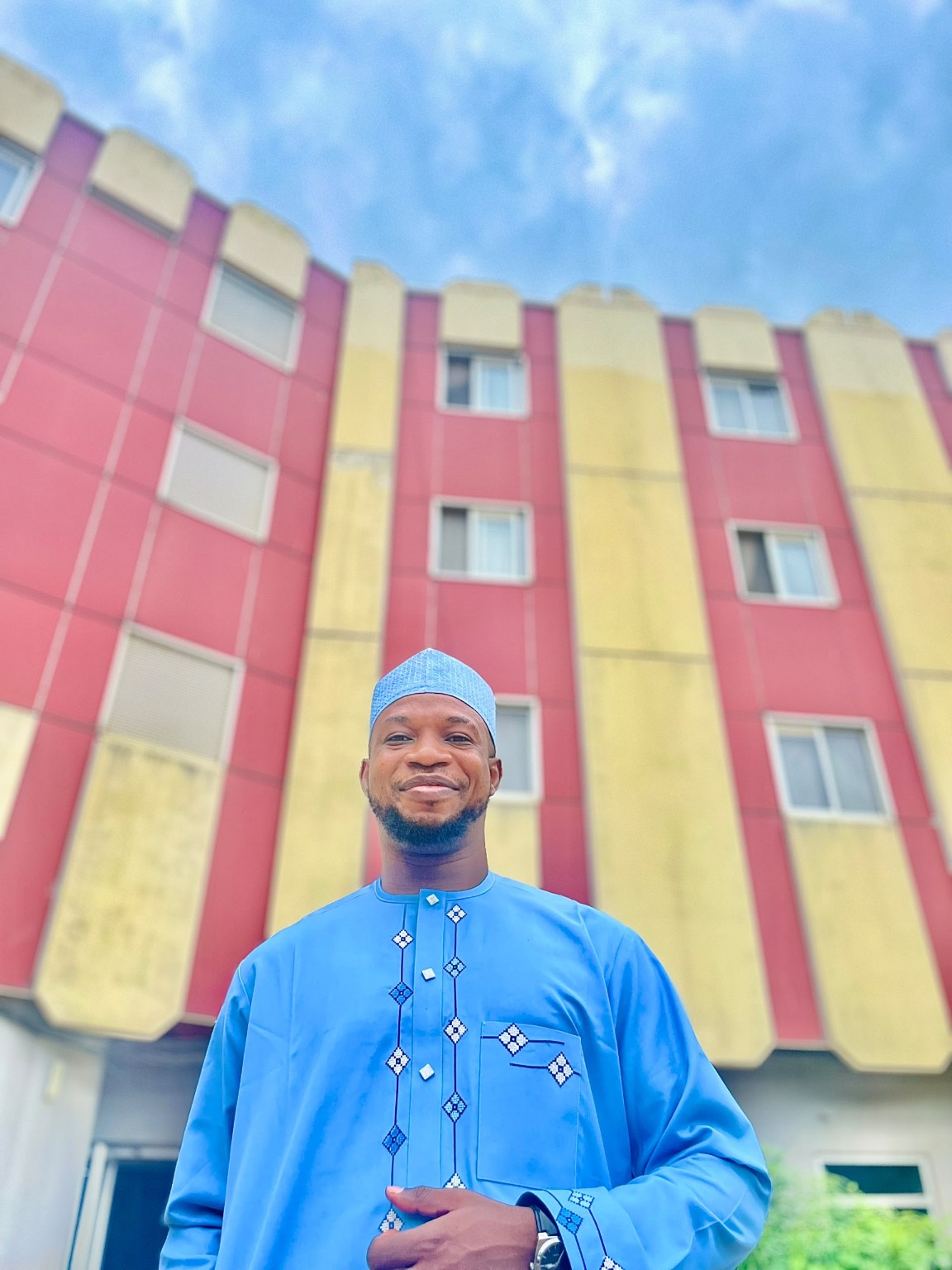 Tobi in blue traditional attire outdoors