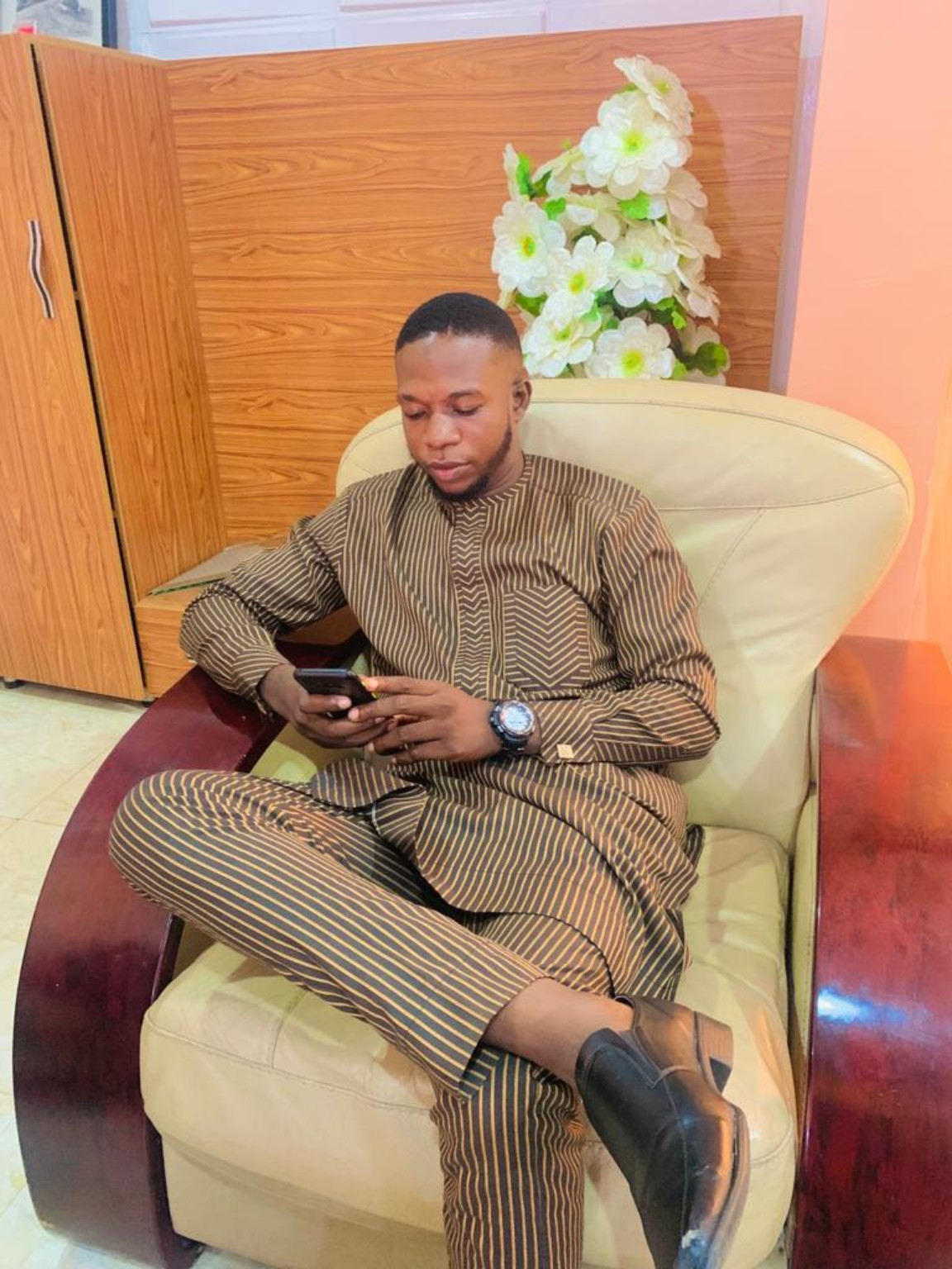 Tobi seated in Nigerian traditional clothing